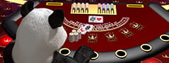 Ein Pandabär hat an einem Blackjack Spieltisch Platz genommen.