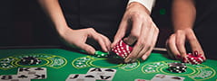 Eine Collage, mit verschiedenen Händen, die Würfel und Jetons an einem Casino Spieltisch bewegen.